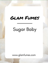 A product image featuring a label with 'Glam Fumes' branding and the words 'Sugar Baby' perfume and body oil beneath it, against a background that appears to be a pile of white sugar crystals.